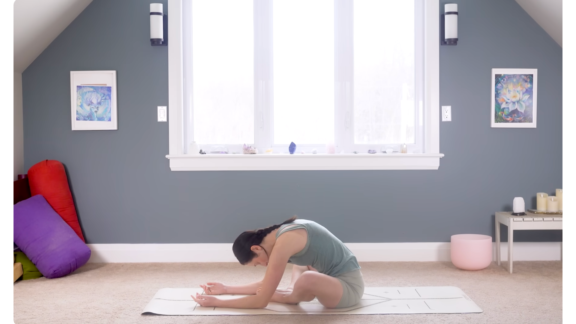 Woman sitting on a mat learning forward and letting her back round in a stretch during yoga for flexibility